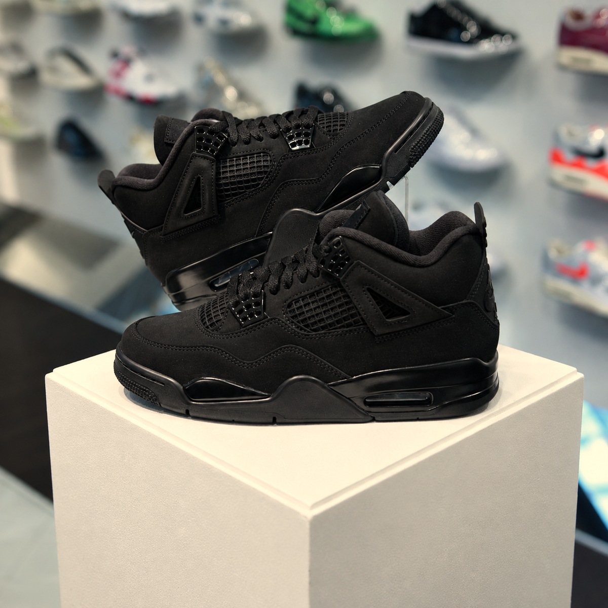 Jordan 4 Retro Black Cat 2025 in de winkel met echte kleur en premium zwarte nubuck afwerking